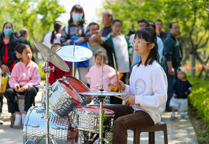 4月20日，一小朋友在山东青岛莱西市月湖公园给游客表演架子鼓。张进刚摄