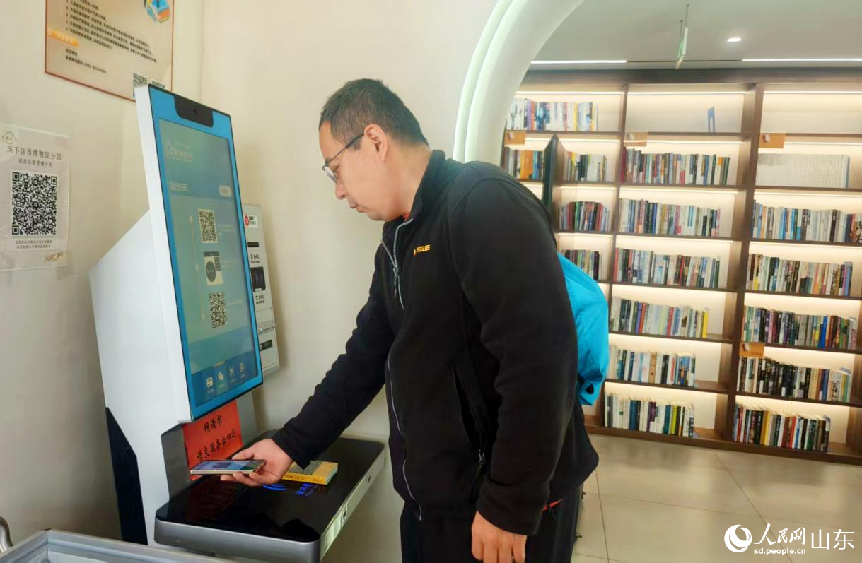 书房设置了“智能借还机”,图为一位市民在借书。人民网记者 宋翠摄