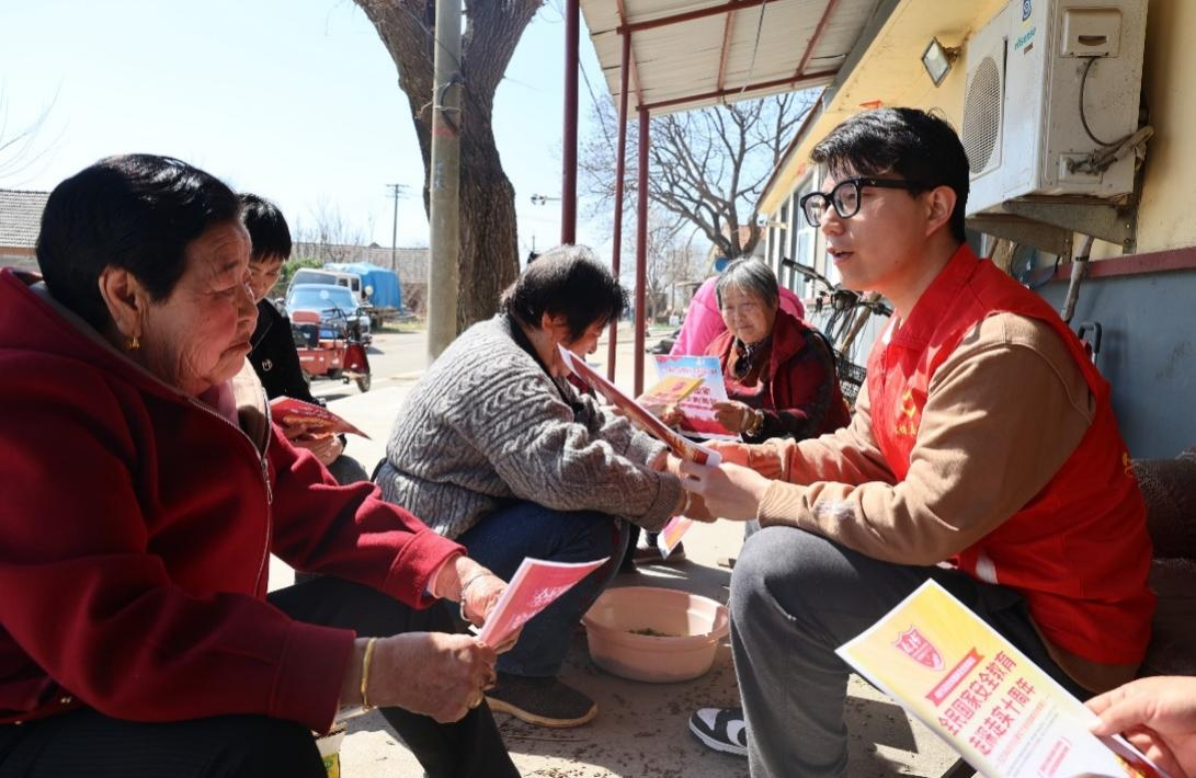 图为文登烟草志愿者在向村民讲解国家安全知识