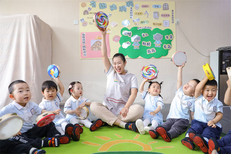 2025年5月14日，在山東省青島市李滄區職工子女愛心托育中心，老師帶領小朋友做游戲。張鷹 攝 
