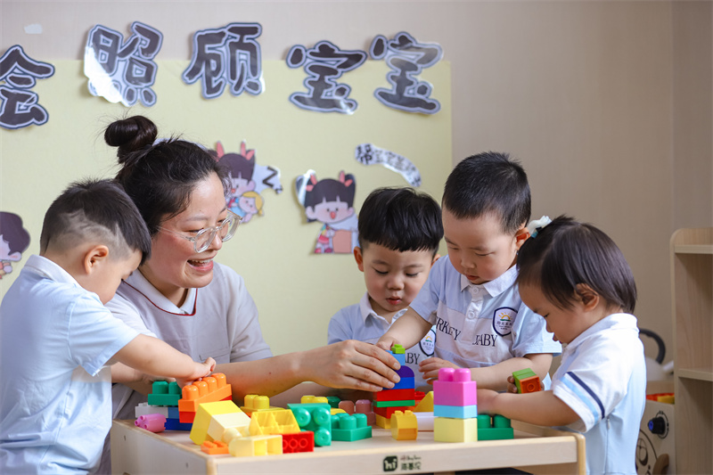2025年5月14日，在山東省青島市李滄區職工子女愛心托育中心，小朋友在老師的精心照護下搭積木。張鷹 攝