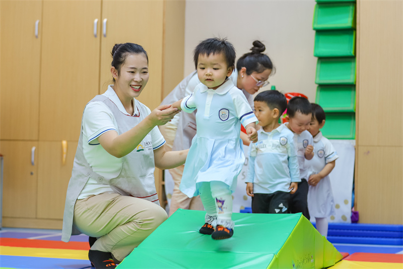 2025年5月14日，在山東省青島市李滄區職工子女愛心托育中心，小朋友在老師的精心照護下做運動。張鷹 攝 