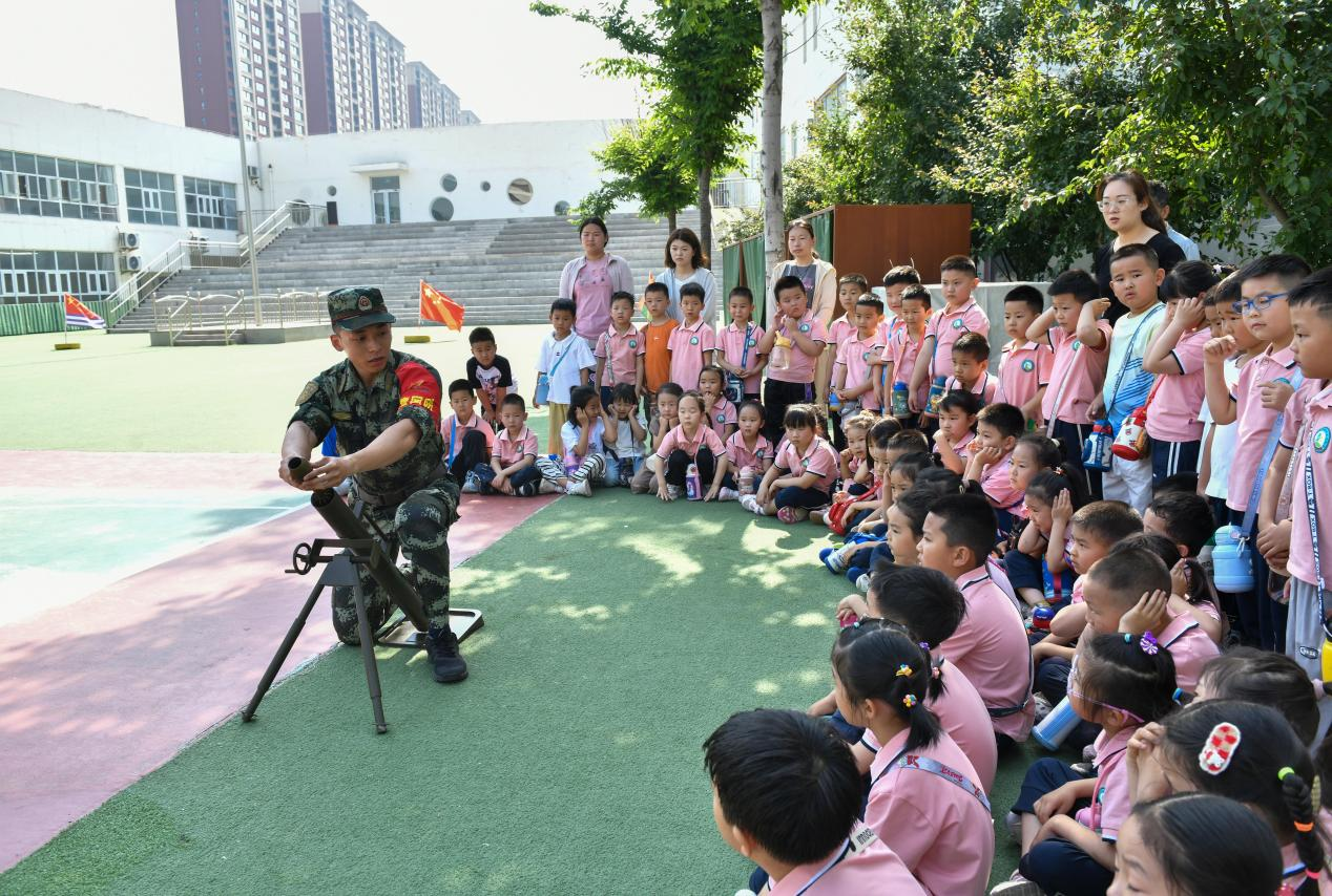 5月20日，在鄒平市全民國防教育進校園活動中，工作人員為黃山實驗幼兒園幼兒講解軍事武器國防知識。