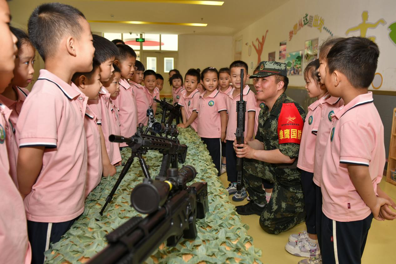 5月20日，在鄒平市全民國防教育進校園活動中，工作人員為黃山實驗幼兒園幼兒講解槍械知識。