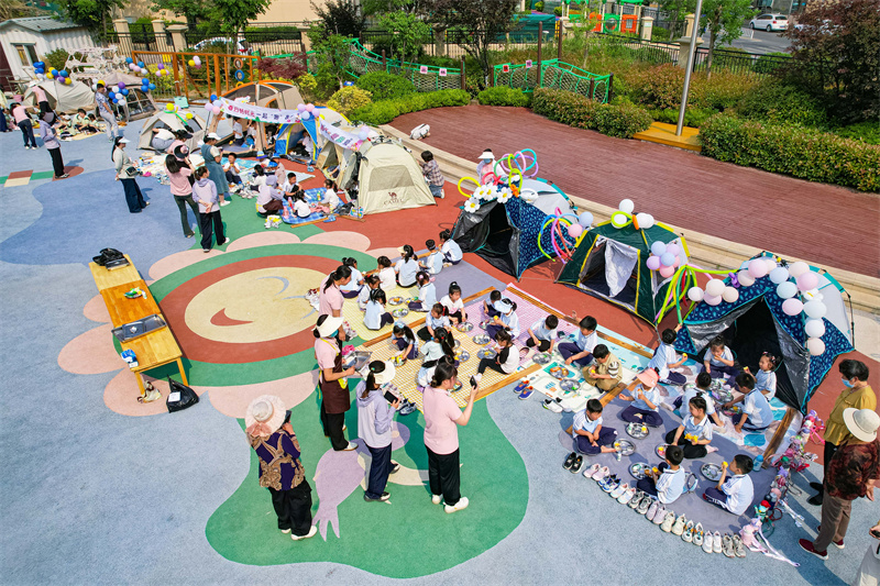 2025年5月26日，小朋友在山东省青岛市李沧区青山路幼儿园开展迎“六一”主题活动中品尝美食。张鹰 摄