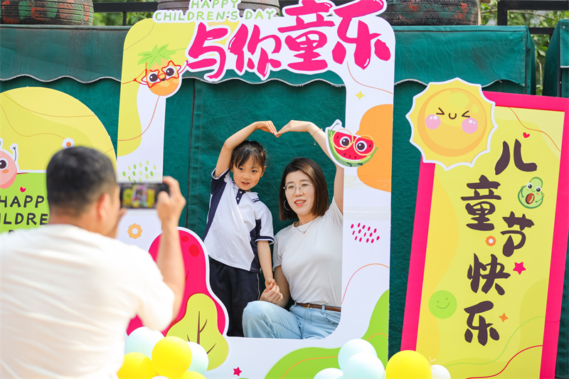 2025年5月26日，在山东省青岛市李沧区青山路幼儿园开展迎“六一”主题活动中，小朋友和家长一起拍照打卡。张鹰 摄