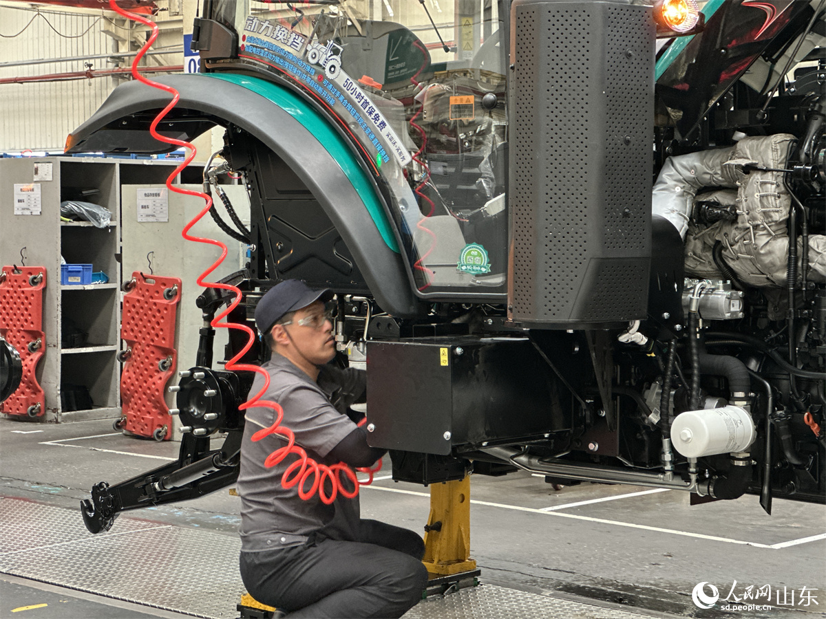 濰柴雷沃智慧農業科技股份有限公司拖拉機工廠總裝車間，工人正在裝配智能拖拉機。人民網 喬姝攝