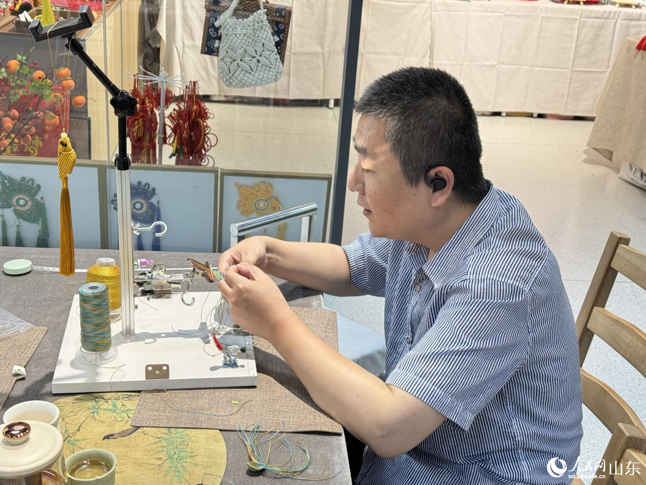 手艺人正在通过精湛的技艺绳编出莲花瓣的弧度。人民网 庄润泽摄