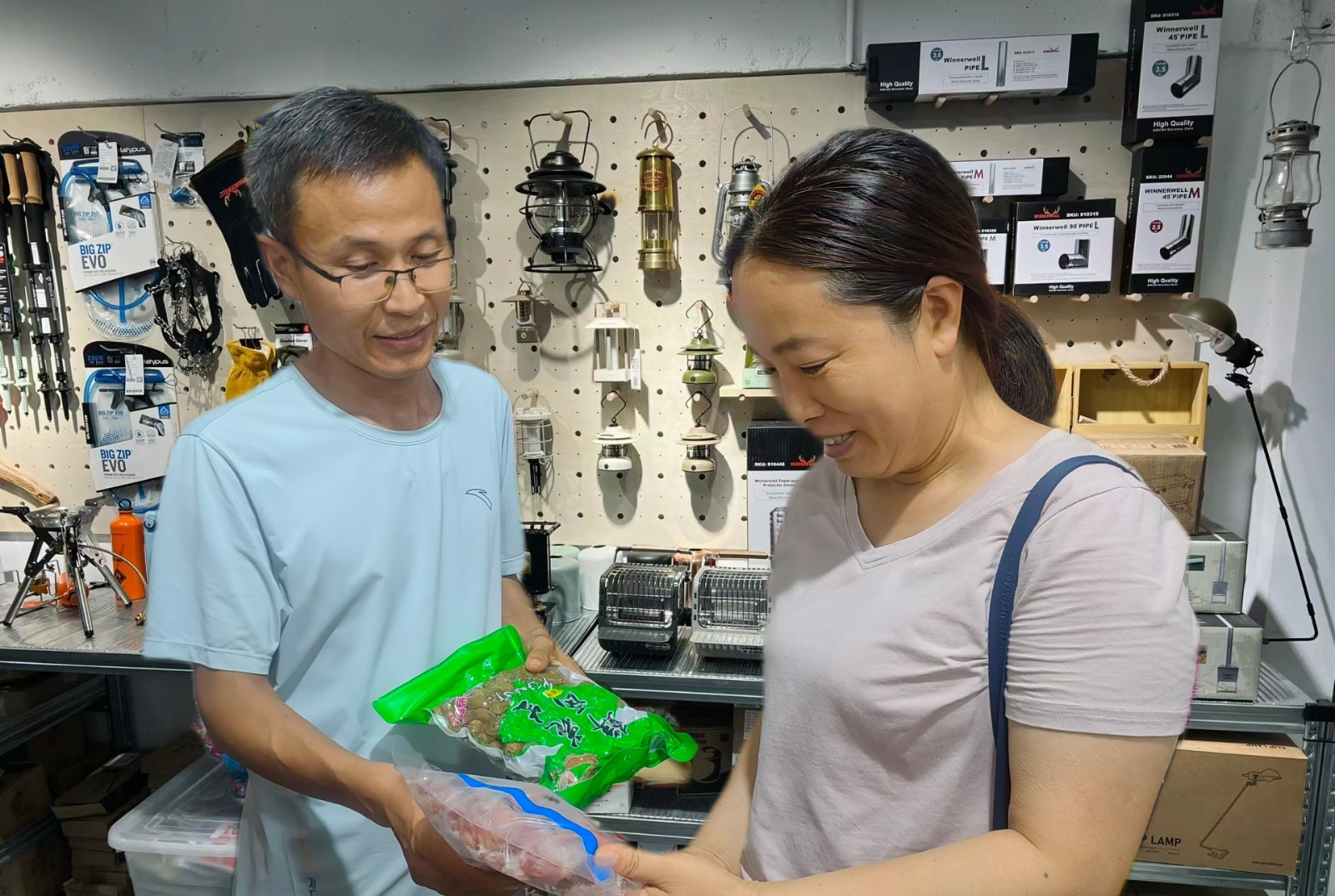 圖為張新峰（左）為顧客介紹燒烤食材