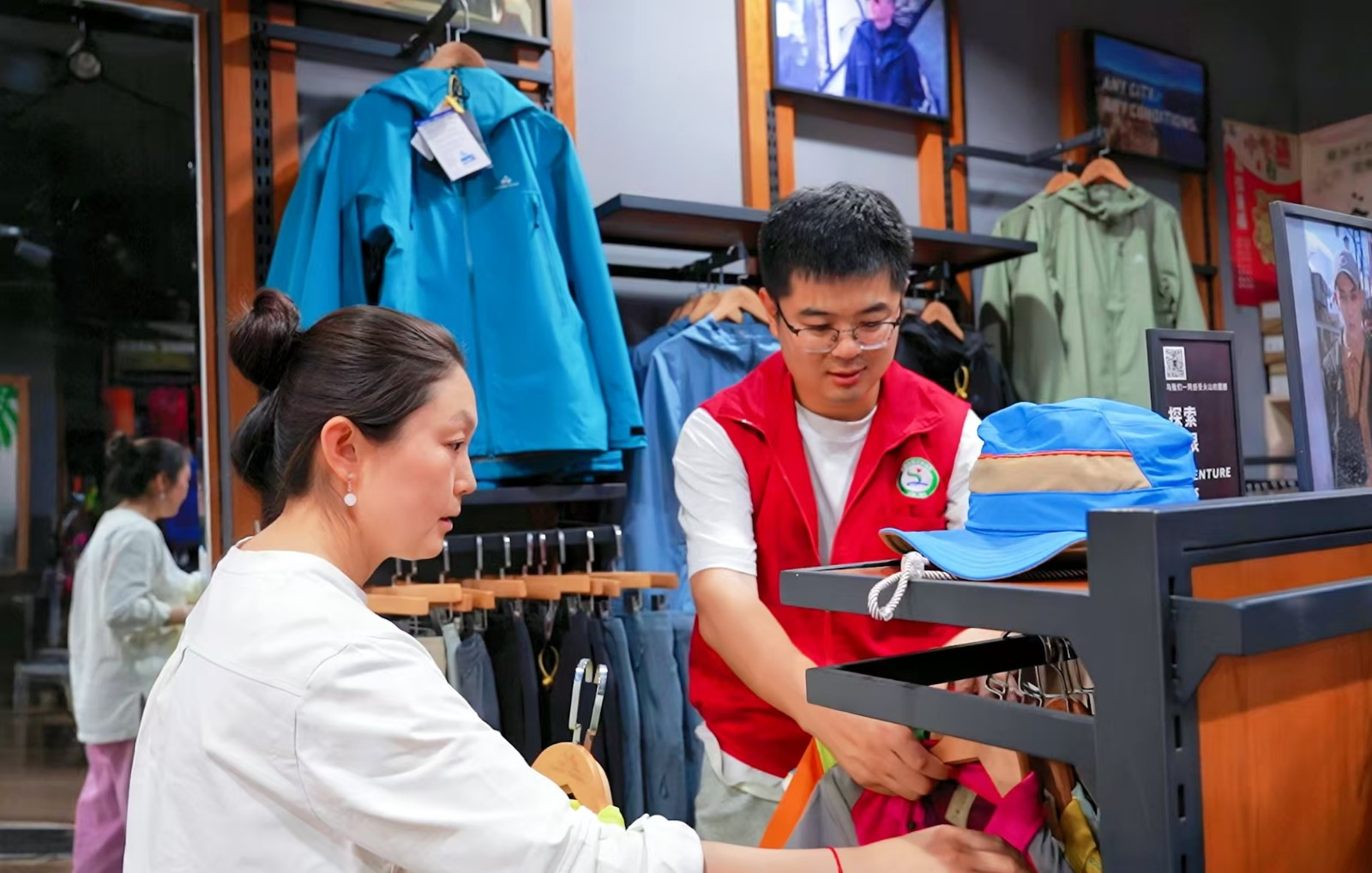 圖為志願者幫助張新峰妻子整理店內商品