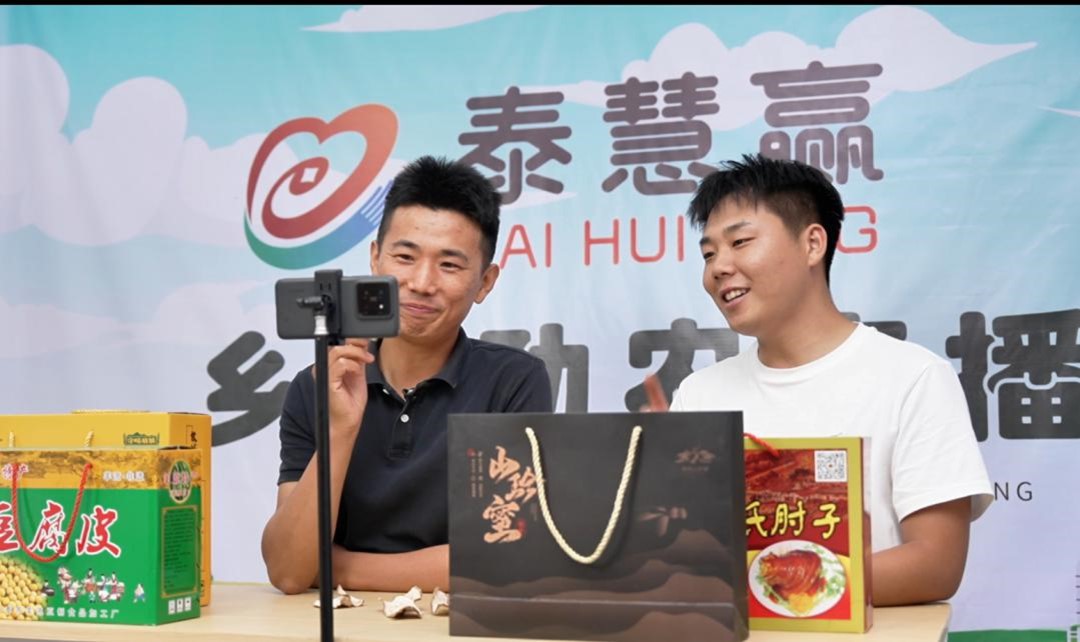 图为梁杰（左）在“泰慧赢”乡村助农直播间介绍当地特产。