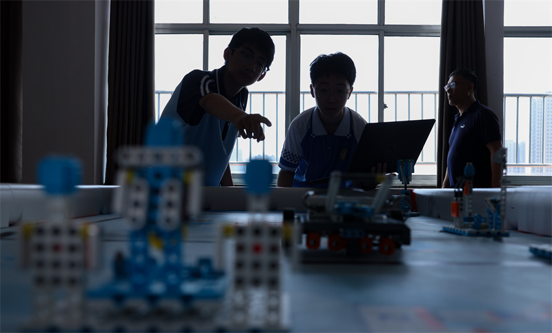 7月12日，在山東省臨沂第十中學，兩名學生正在進行機器人編程調試。