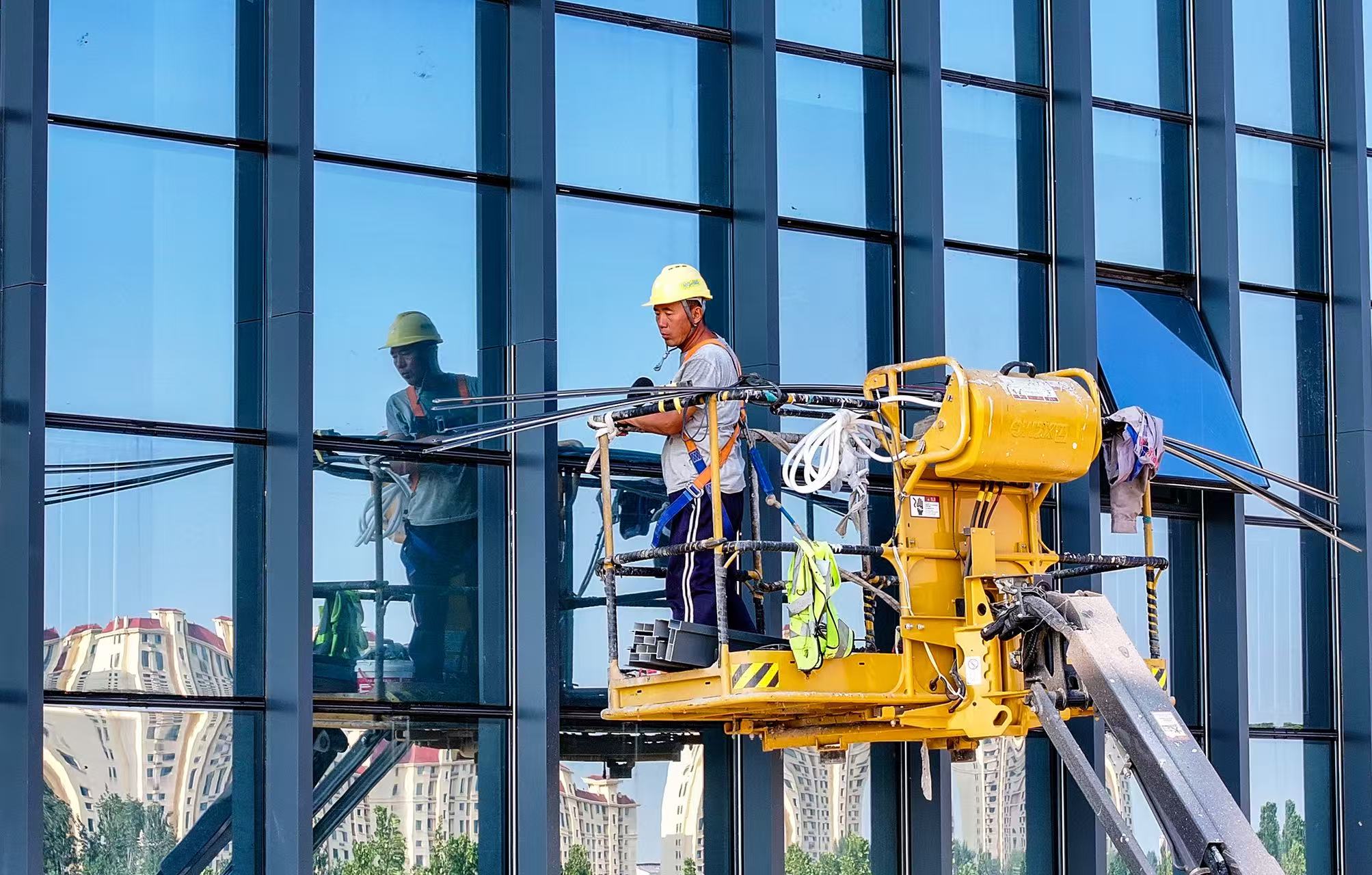 山东省乐陵市经济开区一项目工地，建筑工人避开日中高温在高空中专注作业。