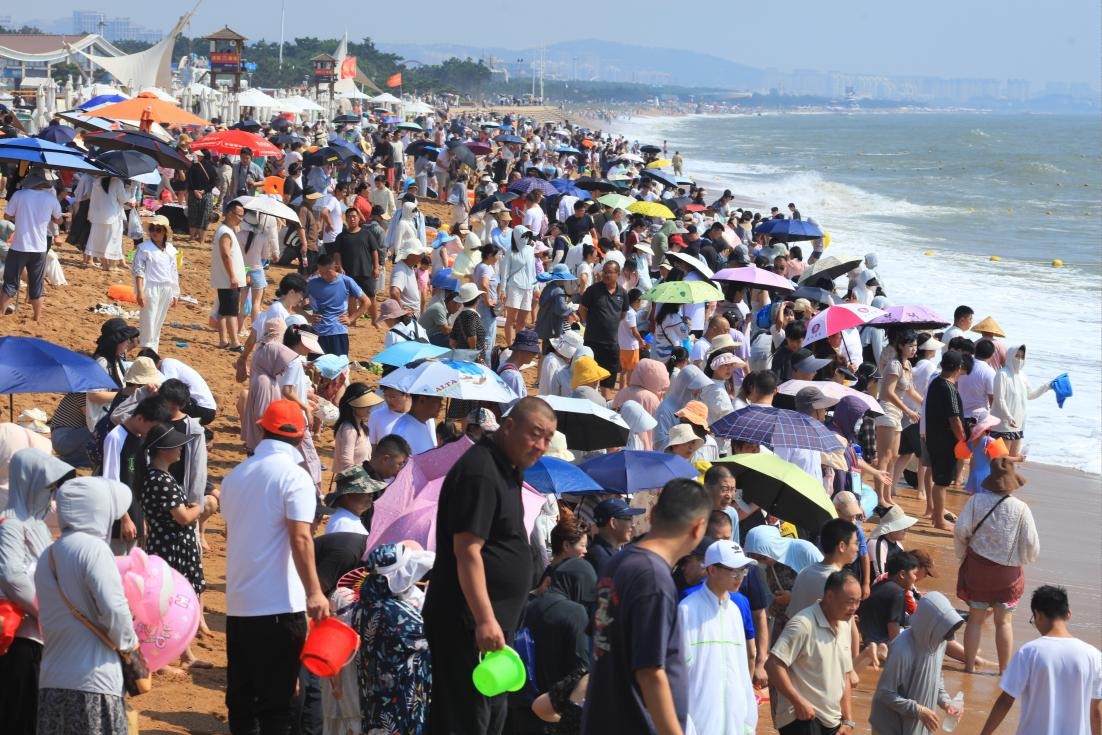 夏日海滨，沙滩上人潮涌动。张守本 摄