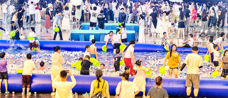 2025年8月5日,在山东省乐陵影视城景区,游客享受电音泼水狂欢节项目带来的清凉与欢乐。