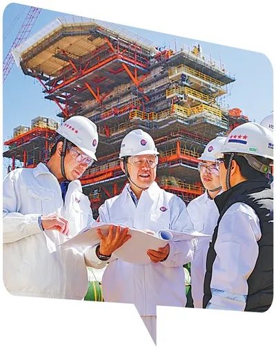 李華軍（左二）在與工作人員討論技術方案。劉  蒞攝