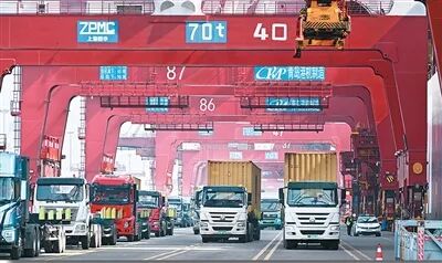 青岛市上合示范区与青岛港互联互通，打造了“前港后站、一体运作”海铁联运服务模式。图为货车在山东港口青岛港运送集装箱。新华社记者 李紫恒摄