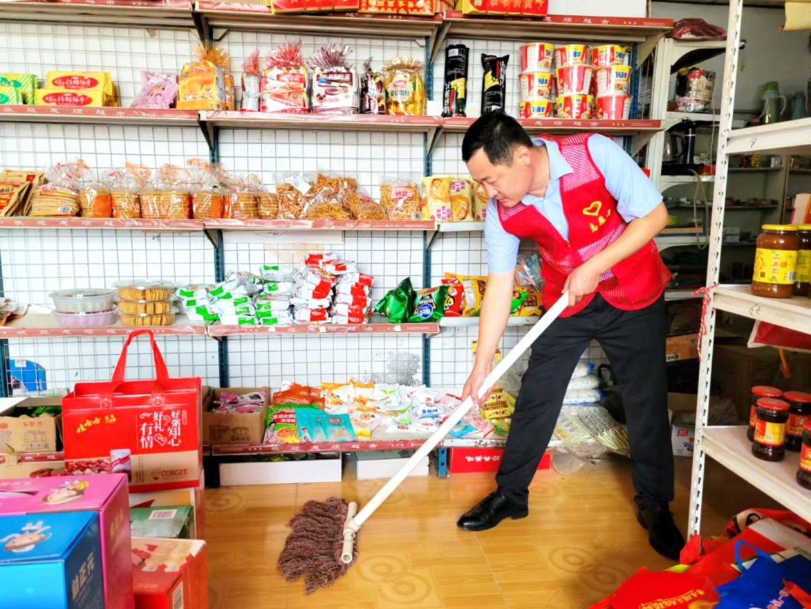 客户经理陈海峰为困难客户清洁店面。
