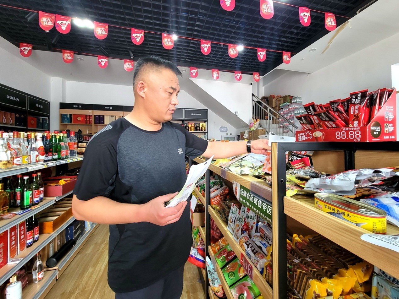 客户经理李建海帮助张宏伟优化商品陈列。