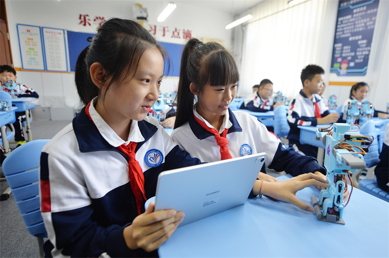 2025年9月25日，在山東省青島市市北區平安路第二小學開展的“校園科技之光”主題系列活動上，兩名學生利用平板電腦編寫程序操控機器人。