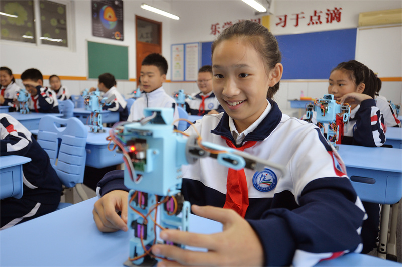2025年9月25日，在山東省青島市市北區平安路第二小學開展的“校園科技之光”主題系列活動上，學生們在學習操控機器人。