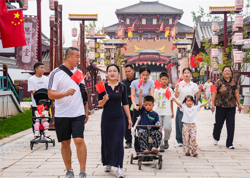 2025年10月1日，游客手持国旗在山东乐陵影视城游览，“中国红”成为一道风景线。