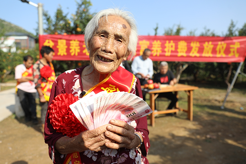 孙大娘手拿“养护费”，笑得合不拢嘴。孙慧摄