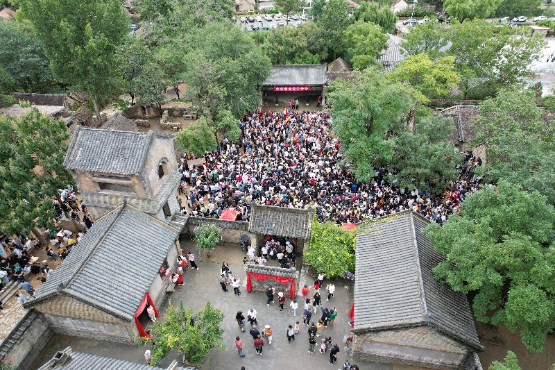 10月3日，在山东省临沂市沂南县常山庄村的山东红嫂家乡旅游区，游客在参与沉浸式互动演绎《重走支前路》（无人机照片）。