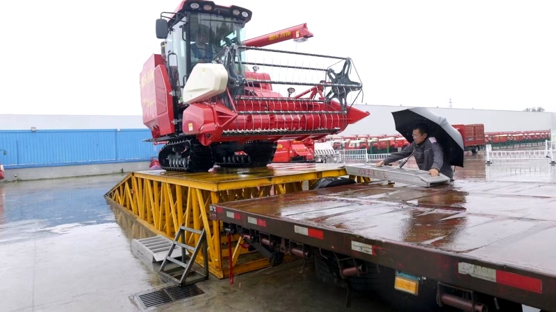 工作人员正冒雨安排装车