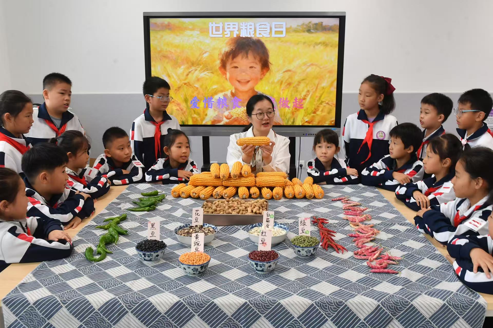 10月15日,在山東省青島市市北區杭州路小學開展的“愛惜糧食 從我做起”主題活動上,老師帶領學生辨識糧食。