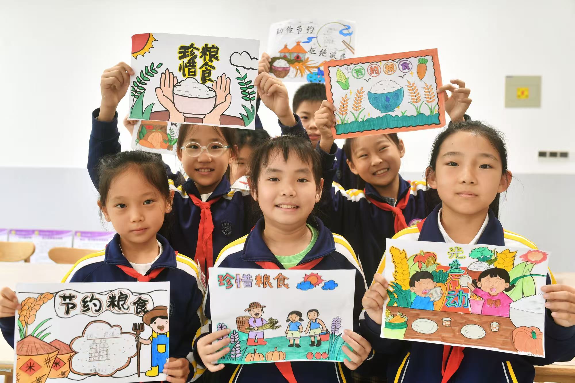 學生們展示繪制的珍惜糧食海報