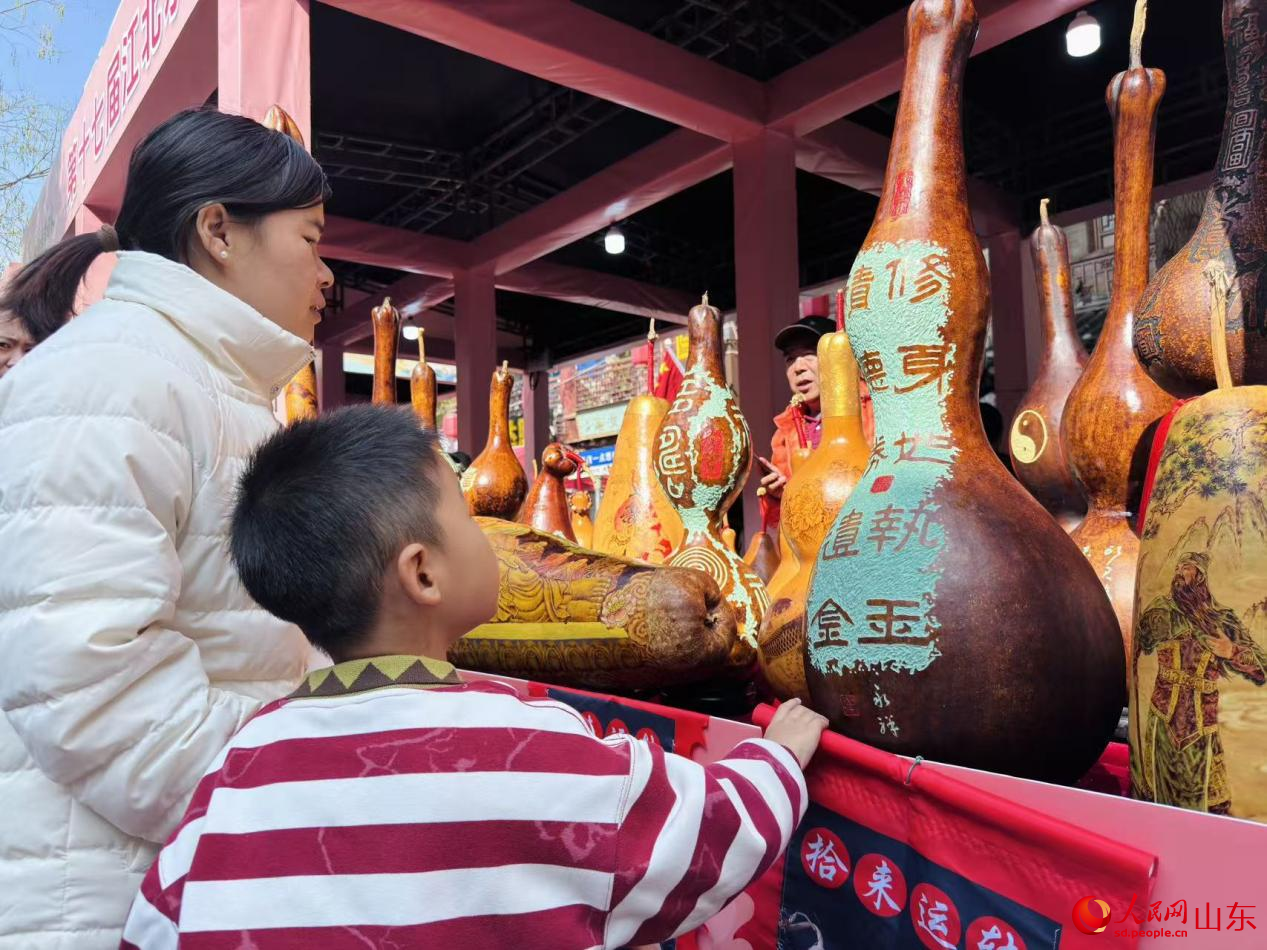 小朋友被琳琅满目的葫芦工艺品吸引驻足。人民网 郑昕桥摄