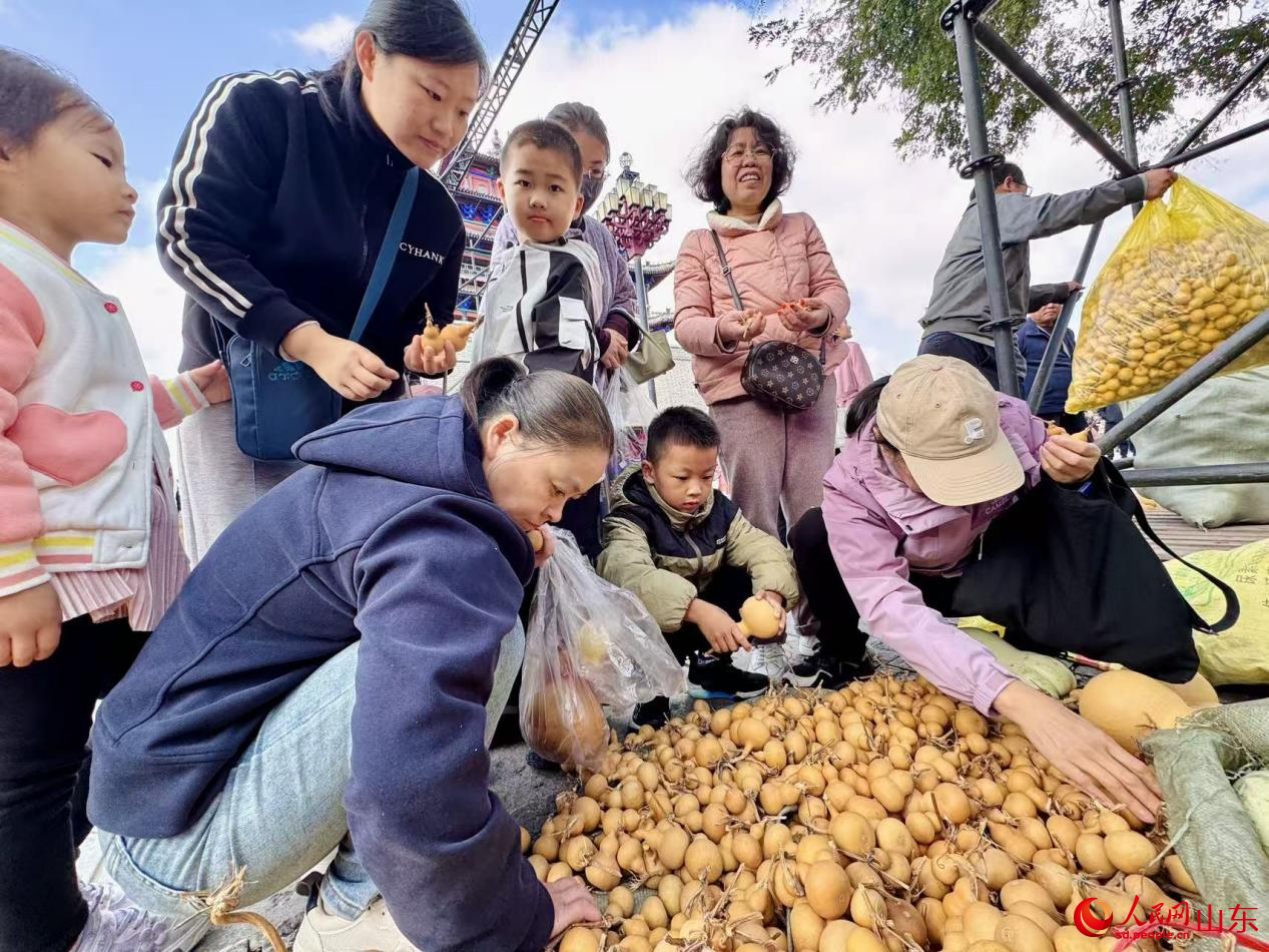 一摊位前,各种形态的素坯葫芦引得游客争相选购。人民网 郑昕桥摄