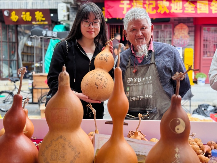 前来参展的葫芦爱好者与手工艺人合影留念。人民网 郑昕桥摄