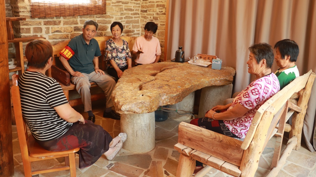 2025年7月，玫瑰鎮北石硤村協商驛站內，協商理事與議事群眾共同開展“微議事”活動。