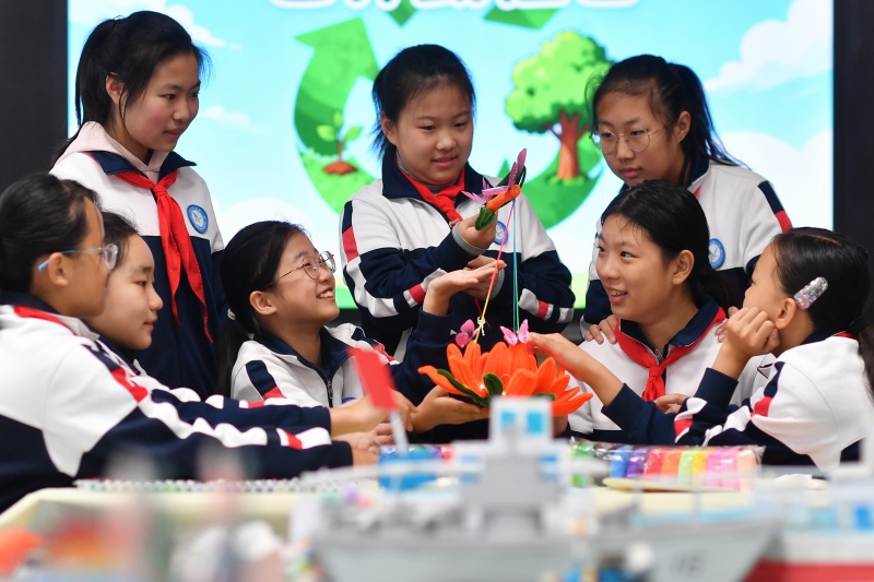 2025年10月31日,在山东省青岛市市北区郑州路小学开展的“变废为宝倡节约”主题活动上,学生们展示利用废旧材料制作的莲花灯。