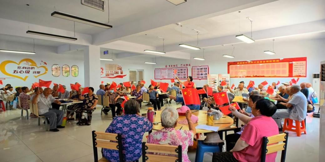 7月1日，桃園新村黨委領辦暖心食堂項目，開餐前教老人唱紅歌、做手勢操。