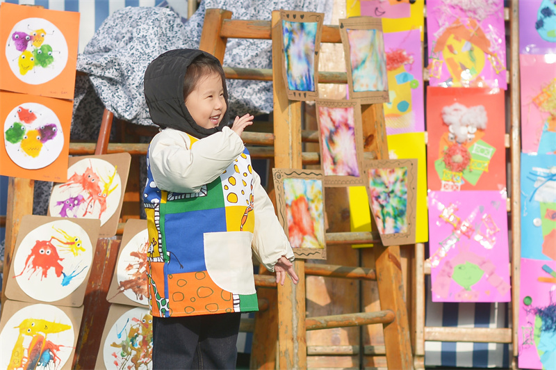 2025年11月25日，小朋友在山东省青岛市市北区高安路幼儿园开展的“色彩日”主题活动上观赏废旧物品创意画。王海滨摄