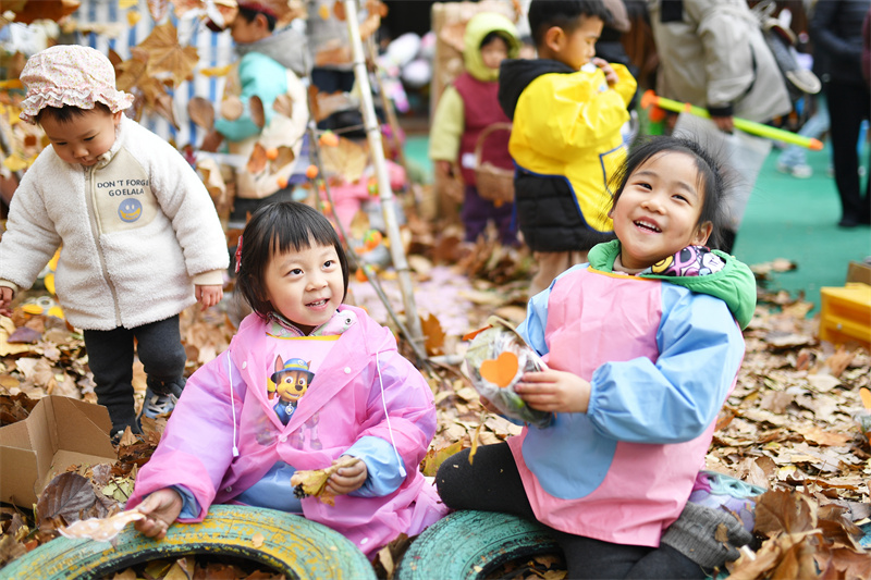 2025年11月25日，小朋友在山东省青岛市市北区高安路幼儿园开展的“色彩日”主题活动上捡拾多彩落叶。王海滨摄