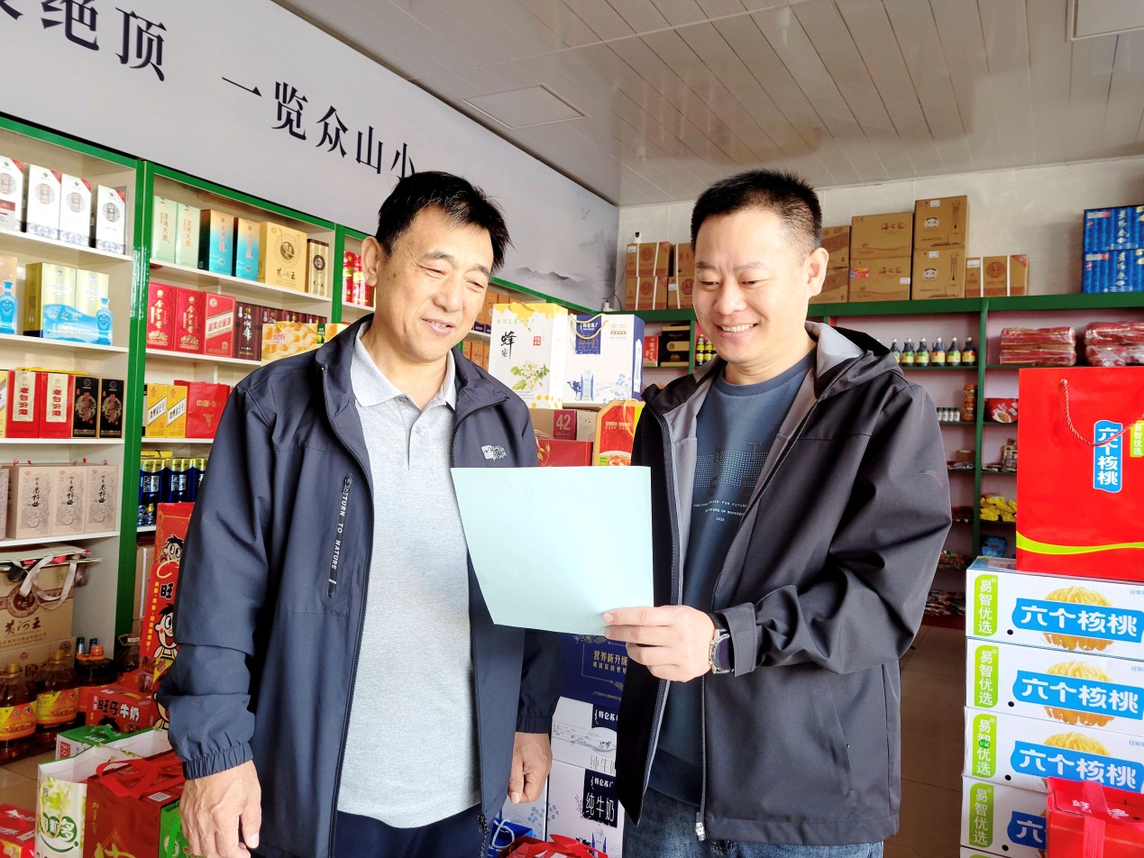 客戶經理劉海濱（右一）幫助便民超市設計陳列專櫃