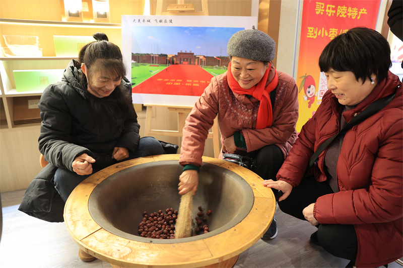 12月19日，游客在山東德州樂陵市的中國金絲小棗文化博物館體驗傳統焦棗手藝，館內棗香彌漫，游客紛紛打卡品嘗。（周廣學攝）