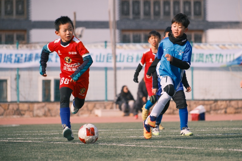 2026年1月1日,在山東省青島市城陽區夏庄街道山色峪鄉村振興齊魯樣板省級片區舉辦的足球邀請賽上,足球小將在帶球進攻。