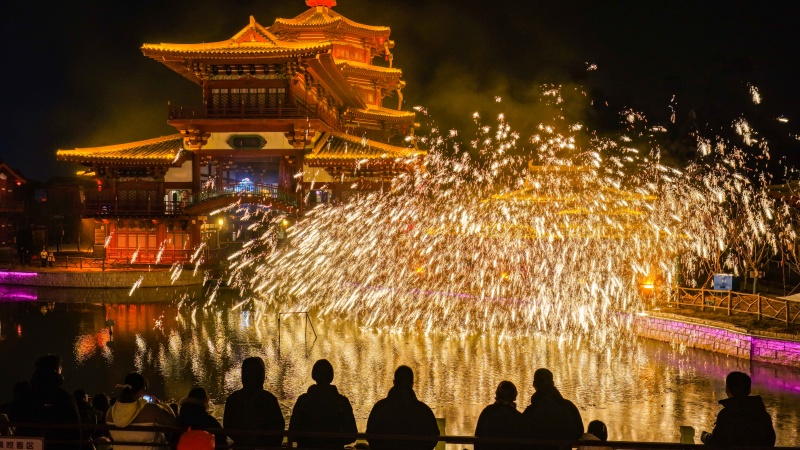 2026年1月1日,游客在山东德州乐陵影视城景区内观看打铁花演出。