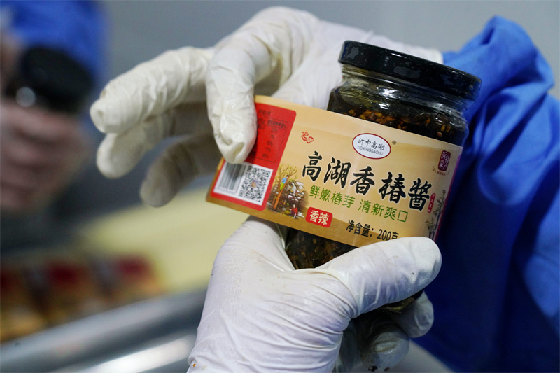 1月6日，在山东省临沂市沂南县岸堤镇泉水庄村“共富工坊”，村民在张贴带有“高湖香椿酱”的标签。