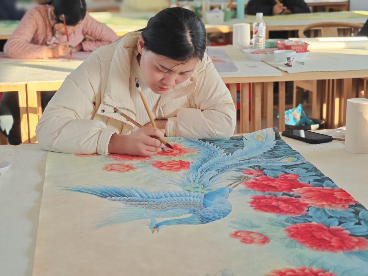 村民正在完成工笔牡丹画。李保珠摄