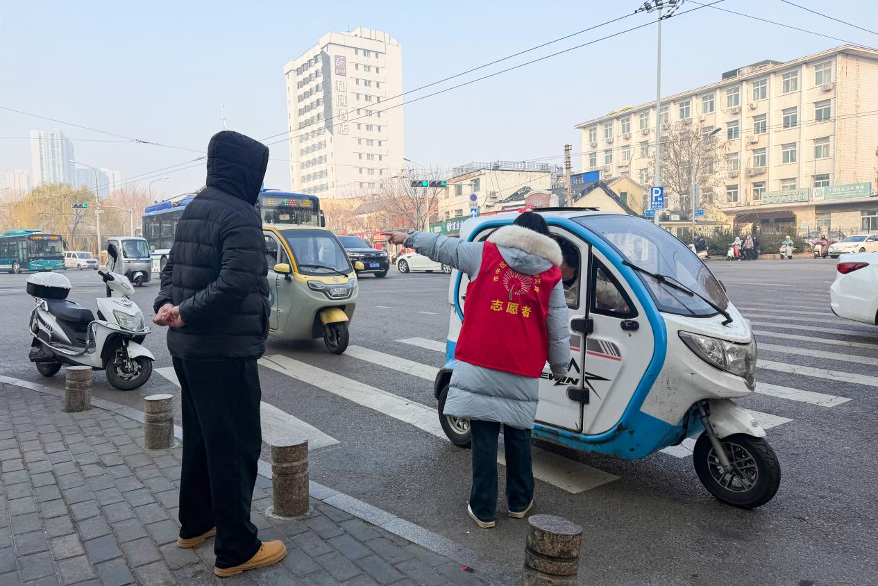 工作人员正在向禁行车辆车主介绍禁行路段。孙依冉摄