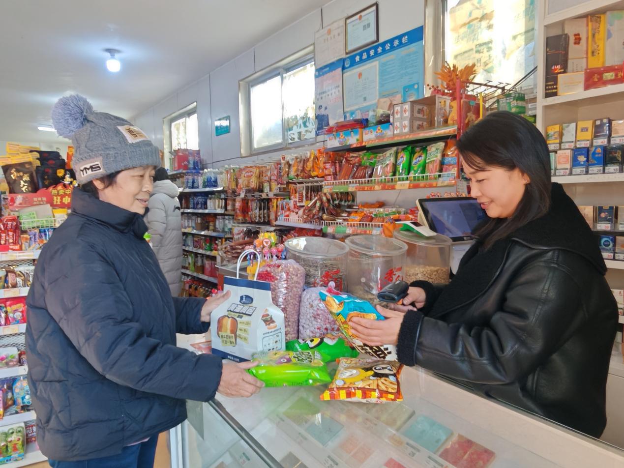 图为村民在整洁的乡村商店选购商品