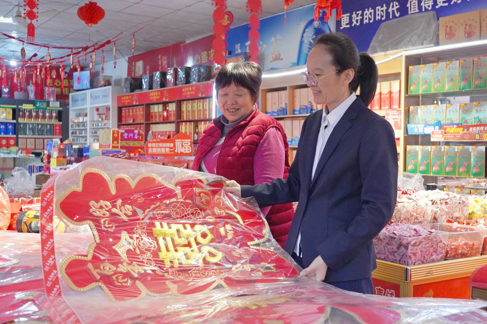 圖為劉曉紅（右一）指導女店主徐立芳調整店內布局