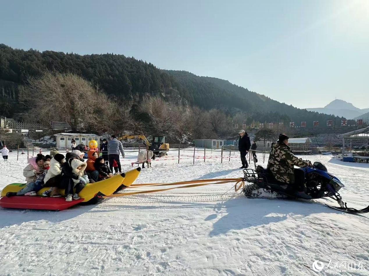 1月24日,游客在济南黄金谷瀑布群风景区戏雪游乐。人民网记者 乔姝摄