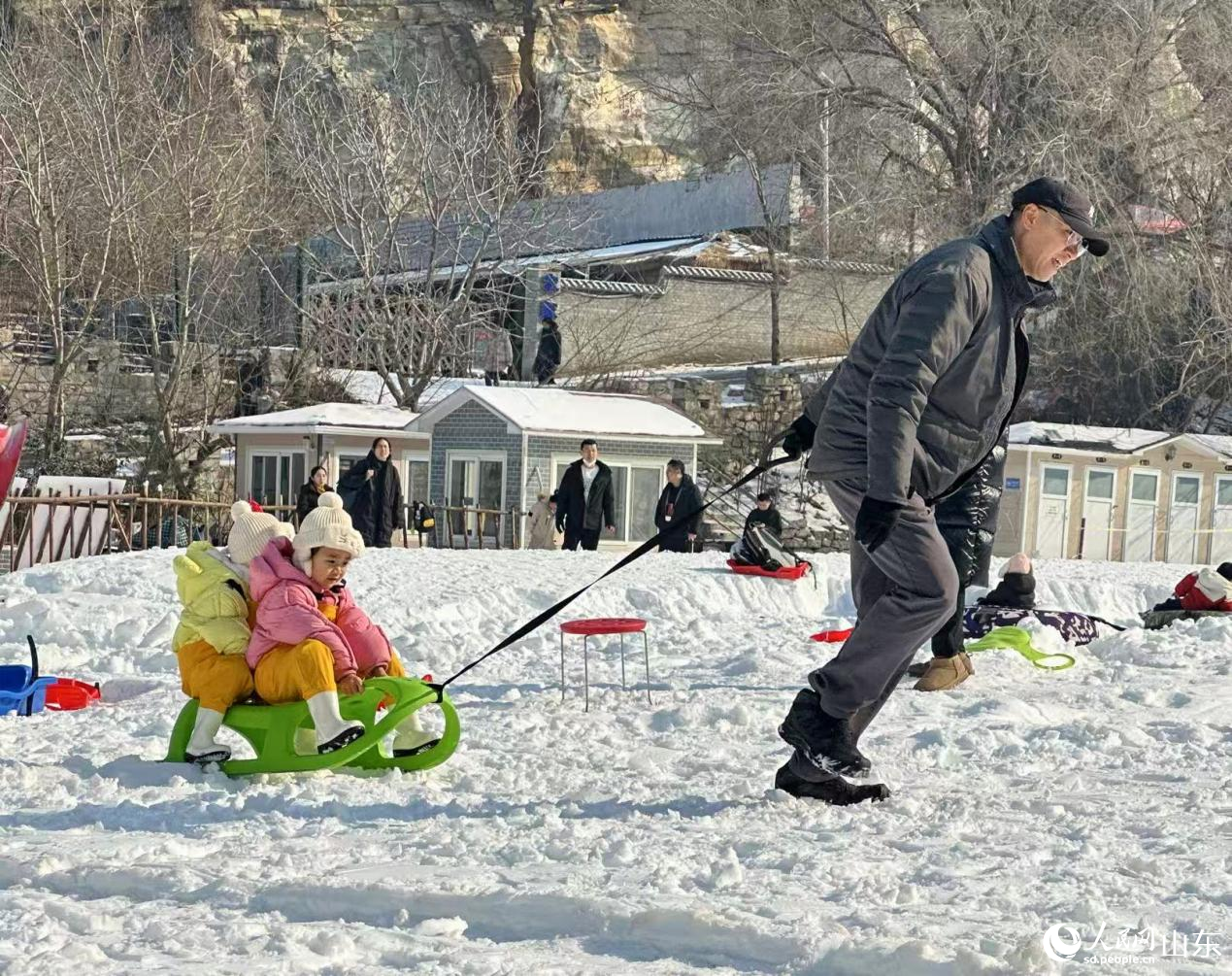 1月24日,游客在济南黄金谷瀑布群风景区戏雪游乐。人民网记者 乔姝摄